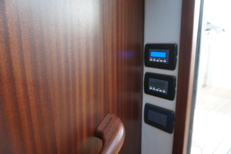  Yacht Photos Pics Interior view of 2021 Jupiter 41 SB with wood paneling and control panel.