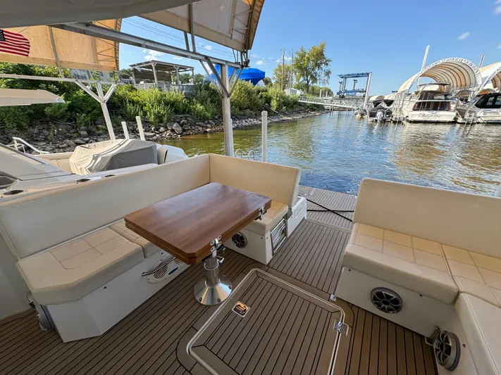 Yacht Rock Yacht Photos Pics 2015 Cruisers Yachts 390 Express Coupe, spacious deck with seating and table, docked by the water.