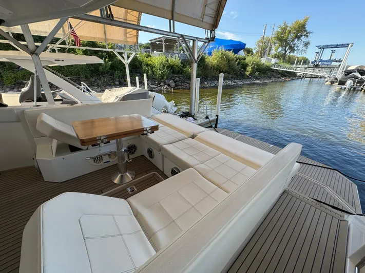 Yacht Rock Yacht Photos Pics 2015 Cruisers Yachts 390 Express Coupe with spacious seating and wooden table by the water.