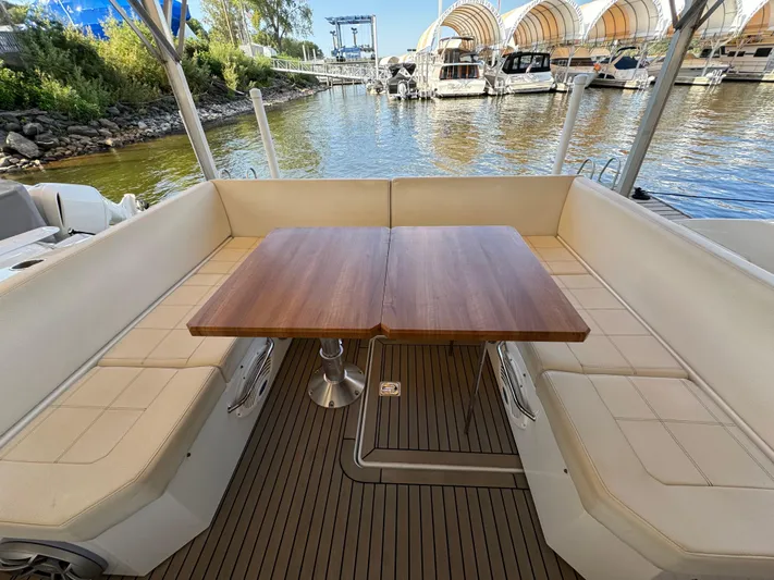 Yacht Rock Yacht Photos Pics 2015 Cruisers Yachts 390 Express Coupe, outdoor seating area with wooden table, docked at marina.