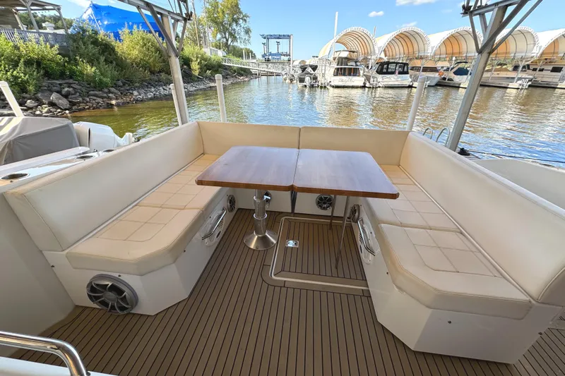 Yacht Rock Yacht Photos Pics 2015 Cruisers Yachts 390 Express Coupe, spacious deck seating with wooden table, marina view.