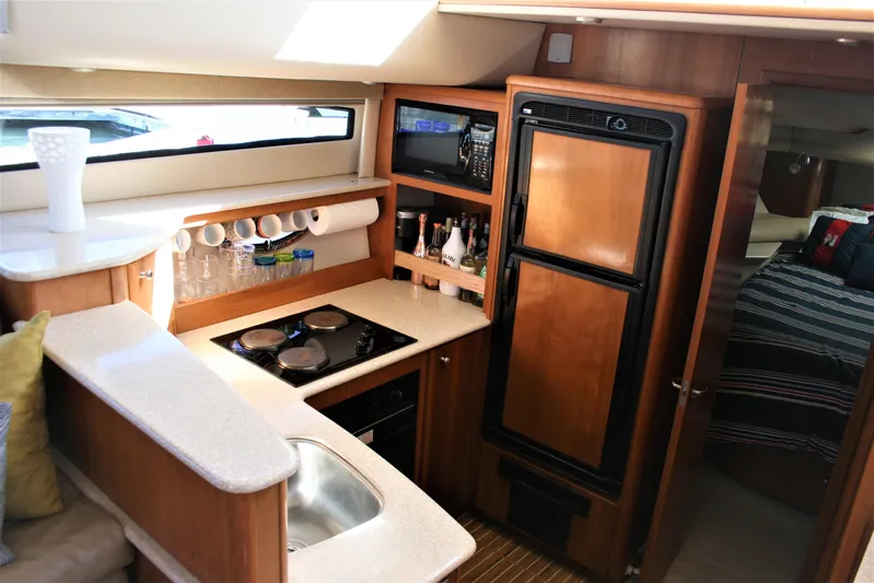 Embracing Life Yacht Photos Pics 2004 Meridian 459 Motoryacht kitchen with wood cabinetry, stove, and refrigerator.