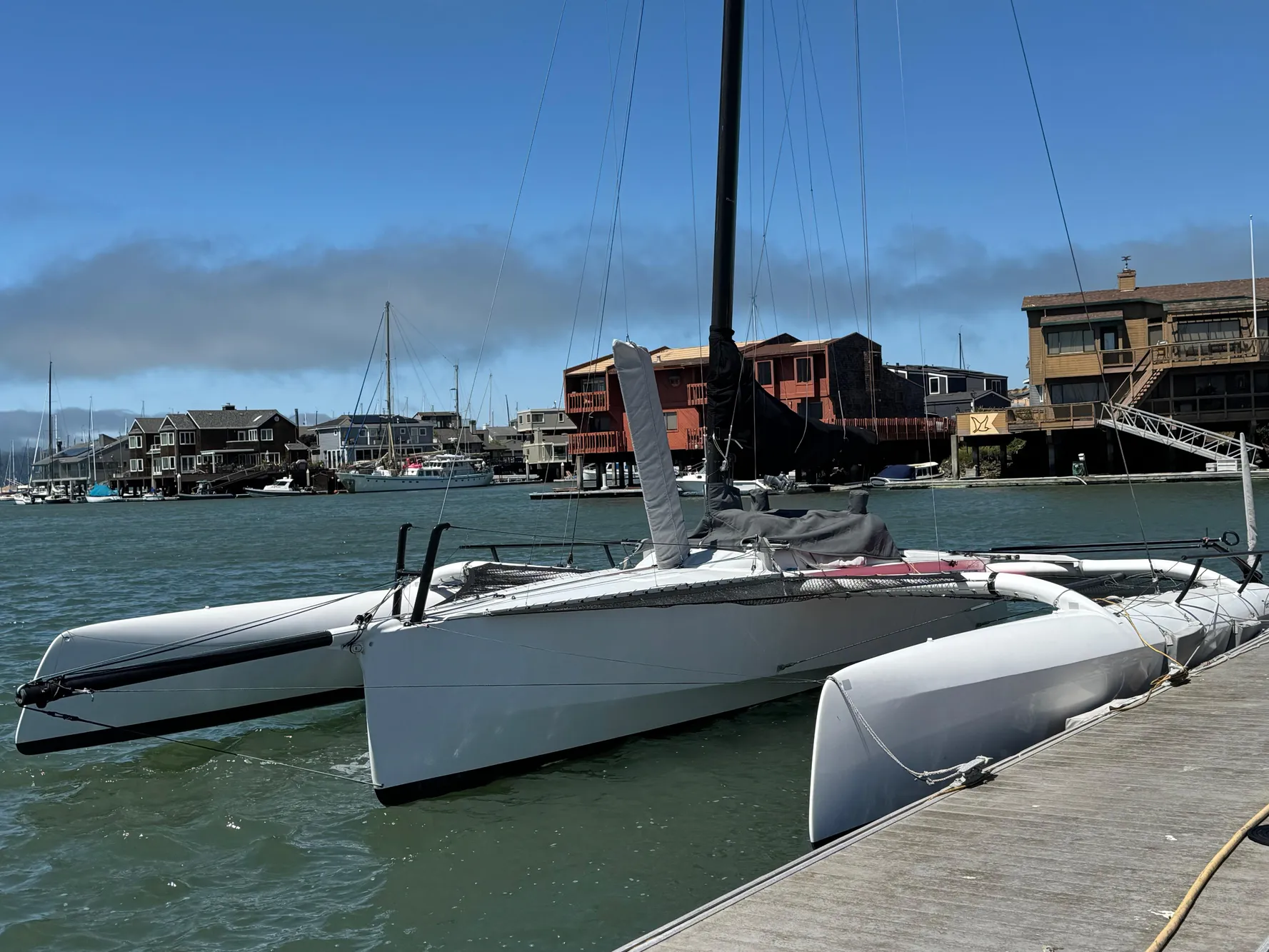 2015 Marstrom Seacart 30 trimaran docked in a marina with waterfront buildings.