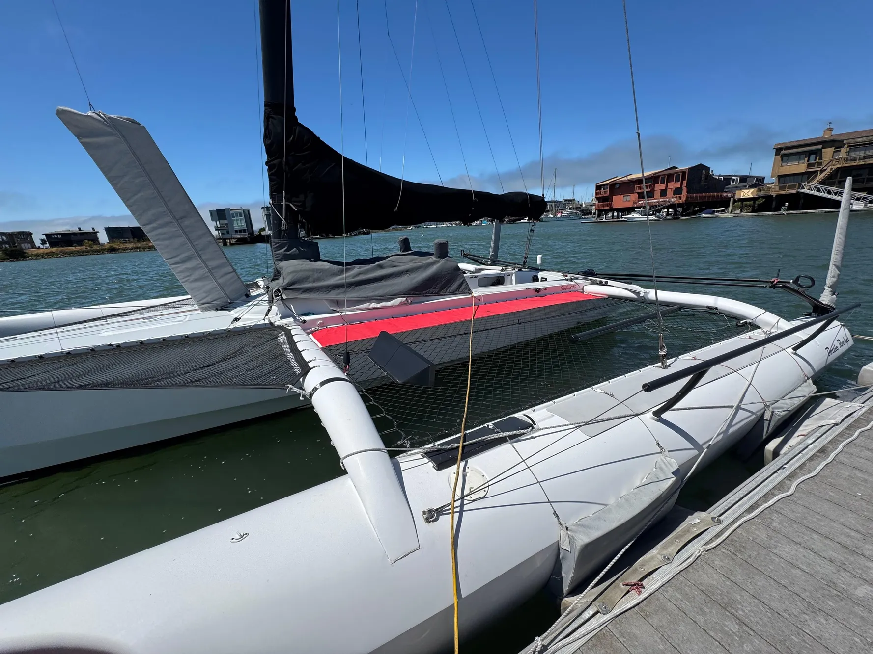 2015 Marstrom Seacart 30 trimaran docked by the waterfront on a sunny day.