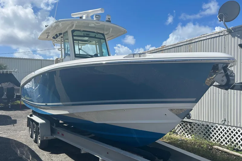 Overtime Yacht Photos Pics 2018 Boston Whaler 330 Outrage boat on trailer under blue sky.