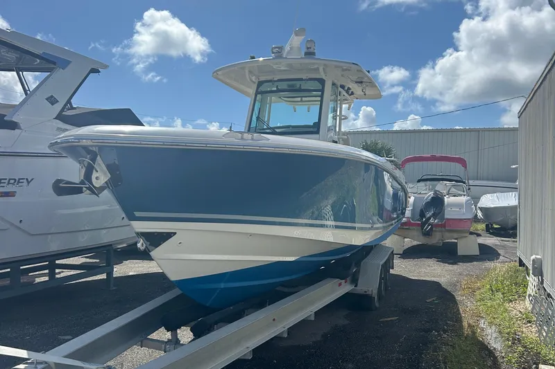 Overtime Yacht Photos Pics 2018 Boston Whaler 330 Outrage boat on trailer under a sunny sky.