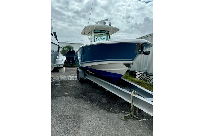 Overtime Yacht Photos Pics 2018 Boston Whaler 330 Outrage boat on trailer under cloudy sky.