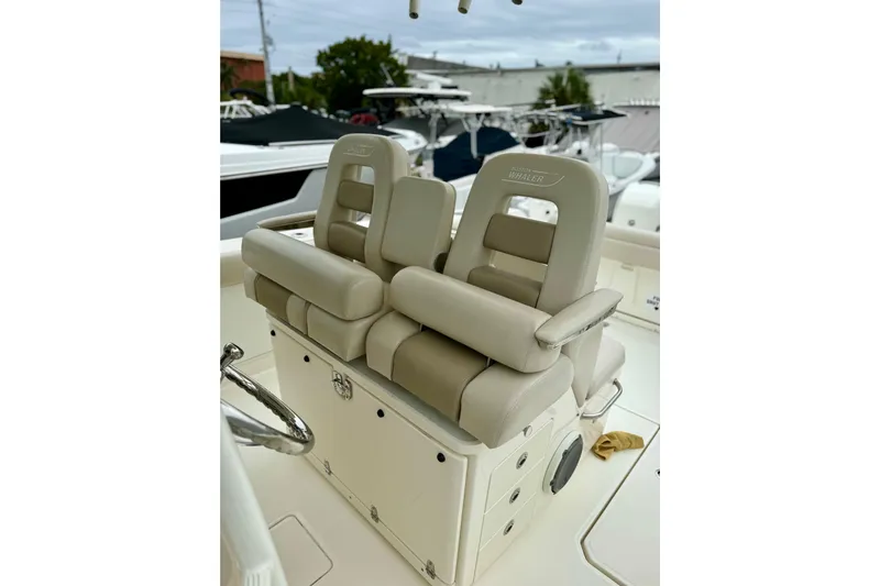 Overtime Yacht Photos Pics 2018 Boston Whaler 330 Outrage boat seats, featuring beige cushioned design and storage compartments.