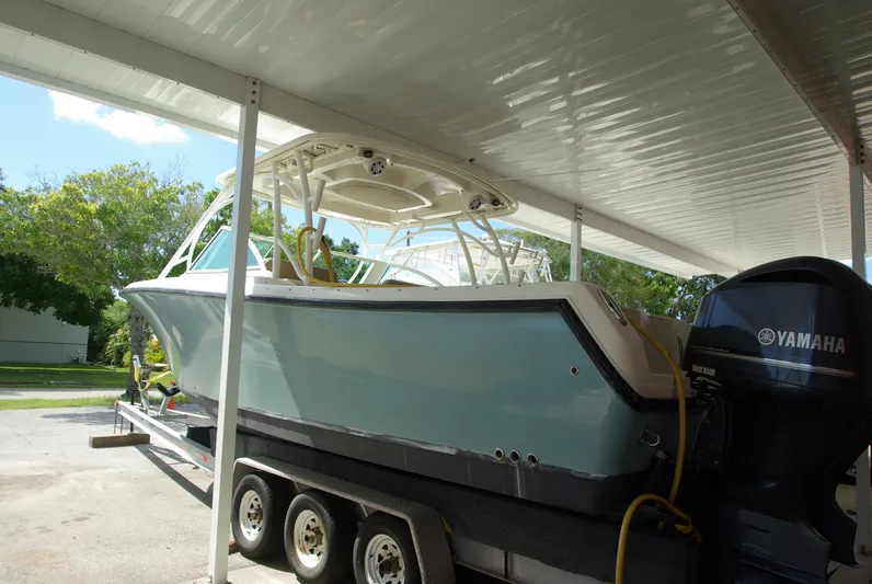  Yacht Photos Pics 2019 Sailfish 325 Dual Console boat on trailer under canopy.