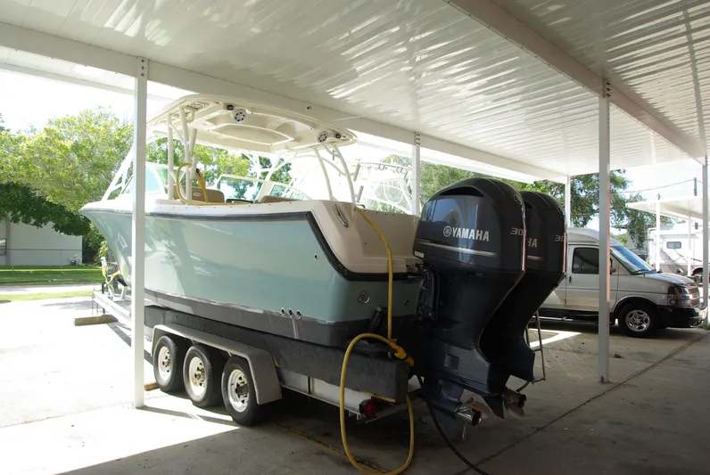  Yacht Photos Pics 2019 Sailfish 325 Dual Console boat on trailer under shelter with Yamaha outboard motor.