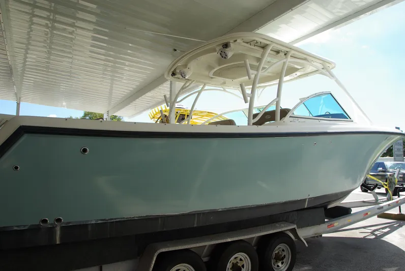  Yacht Photos Pics 2019 Sailfish 325 Dual Console boat on trailer under canopy.