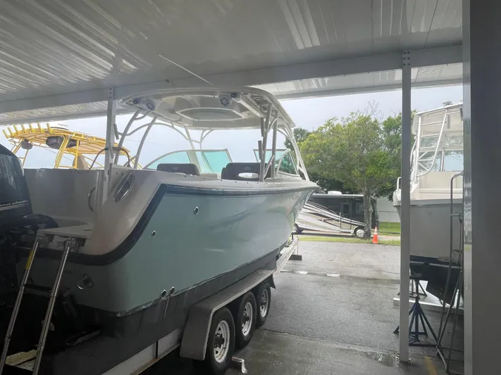 Yacht Photos Pics 2019 Sailfish 325 Dual Console boat on trailer under shelter.