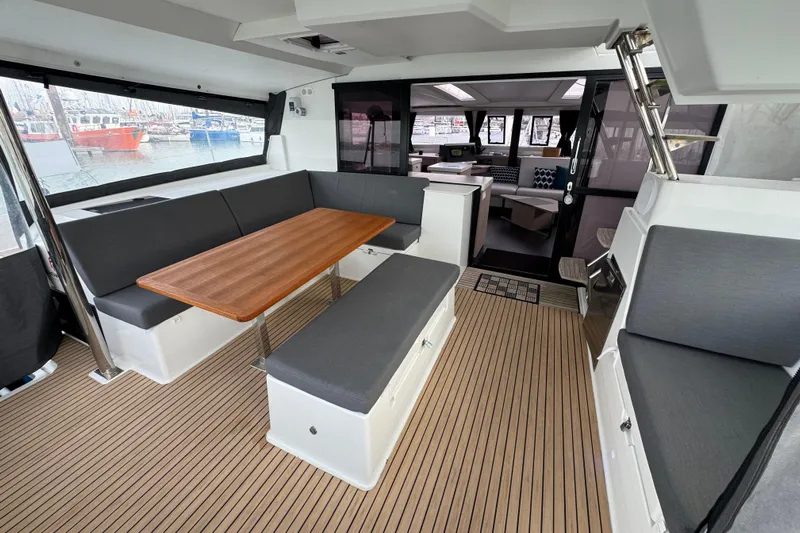 Lupa Di Mare Yacht Photos Pics Spacious interior of 2021 Fountaine Pajot Saona 47 catamaran with modern seating and wooden table.