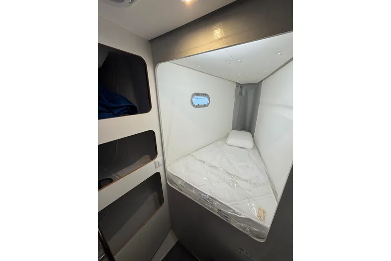 Lupa Di Mare Yacht Photos Pics Cozy cabin interior of 2021 Fountaine Pajot Saona 47 catamaran with bed and porthole.