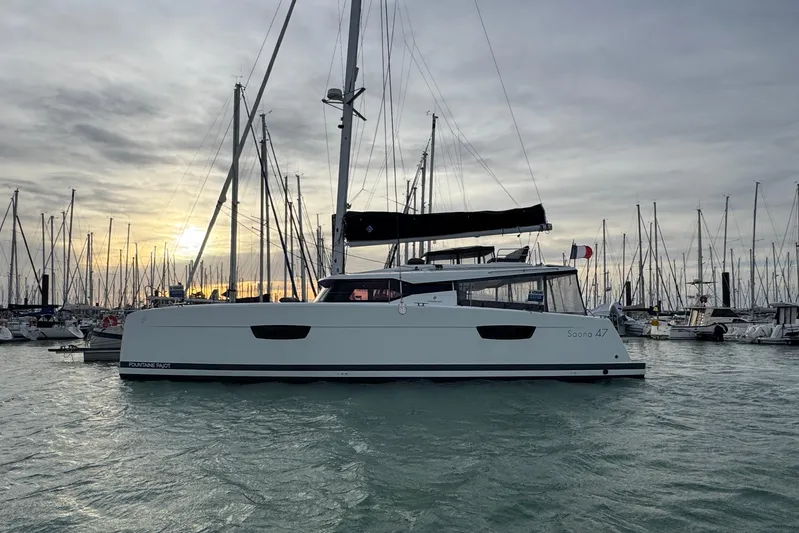 Lupa Di Mare Yacht Photos Pics 2021 Fountaine Pajot Saona 47 catamaran sailing at sunset in a marina.