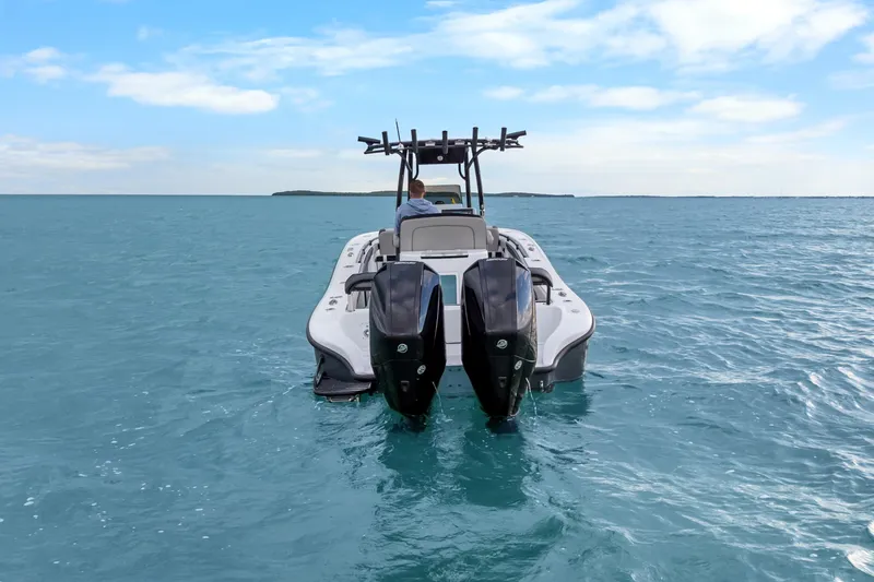  Yacht Photos Pics 2024 Yellowfin 26 Hybrid boat on open water, featuring dual outboard engines.