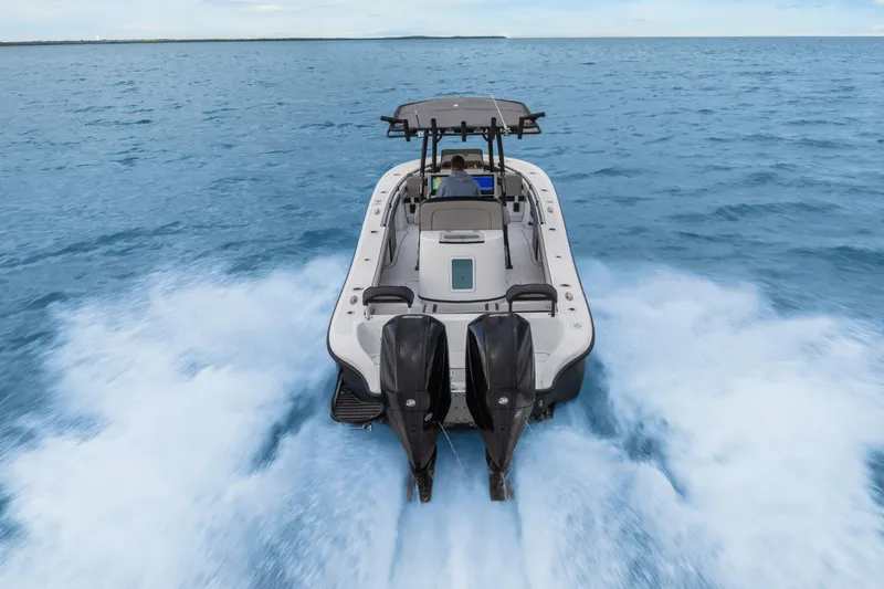  Yacht Photos Pics 2024 Yellowfin 26 Hybrid boat cruising on open water, rear view.