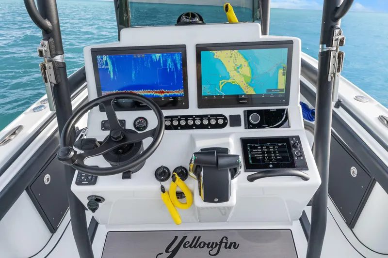  Yacht Photos Pics 2024 Yellowfin 26 Hybrid boat dashboard with navigation screens and steering wheel.