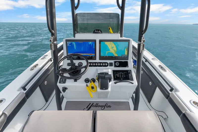  Yacht Photos Pics 2024 Yellowfin 26 Hybrid boat dashboard with navigation screens on open water.