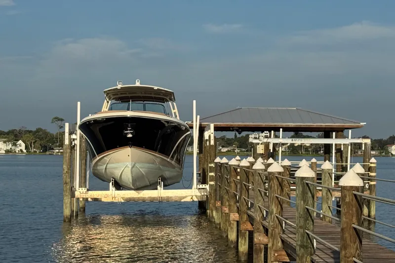  Yacht Photos Pics 2016 Chris-Craft Launch 36 boat docked on a lift by a wooden pier.