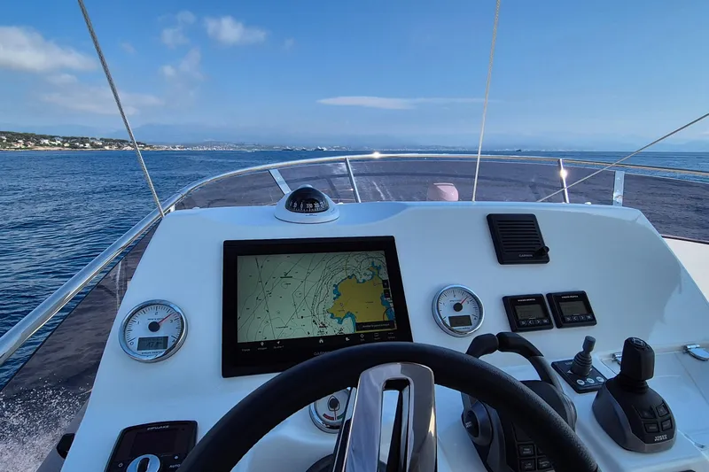 Ker Lann Yacht Photos Pics Cockpit view of 2022 Prestige 460 yacht with navigation display and controls, cruising on open water.