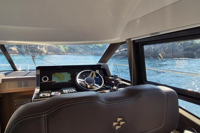 Ker Lann Yacht Photos Pics Interior view of 2022 Prestige 460 yacht cockpit with navigation system and scenic ocean backdrop.