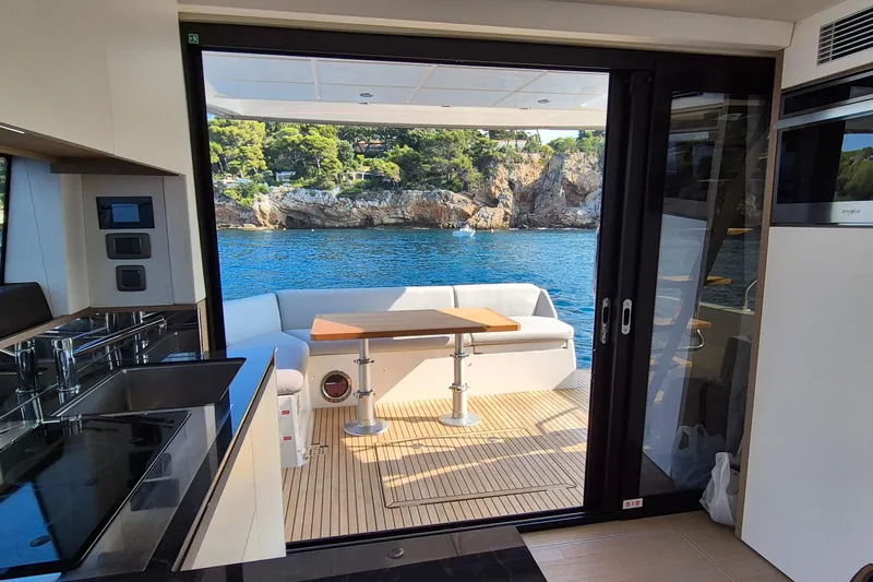 Ker Lann Yacht Photos Pics Interior view of 2022 Prestige 460 yacht with open deck and scenic ocean backdrop.