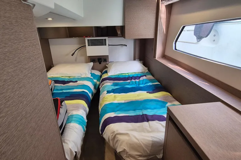 Ker Lann Yacht Photos Pics Twin beds in a 2022 Prestige 460 yacht cabin with colorful striped bedding.