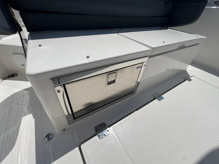 Chill Yacht Photos Pics 2025 Nimbus T8 boat interior with built-in storage compartment and cushioned seating.