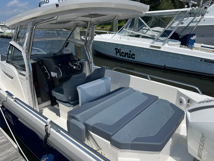 Chill Yacht Photos Pics Nimbus T8 2025 boat with cushioned seating, docked beside another vessel.