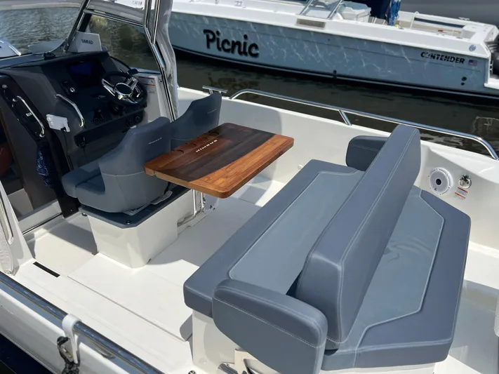 Chill Yacht Photos Pics Interior of 2025 Nimbus T8 boat with seating and wooden table.