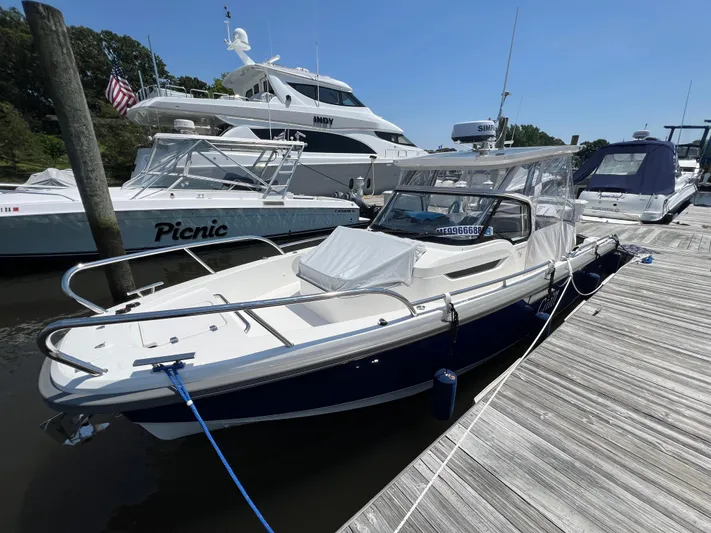 Chill Yacht Photos Pics Nimbus T8 2025 boat docked at marina, surrounded by other vessels on a sunny day.