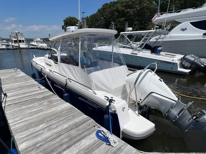 Chill Yacht Photos Pics 2025 Nimbus T8 boat docked at marina, featuring sleek design and modern outboard motor.