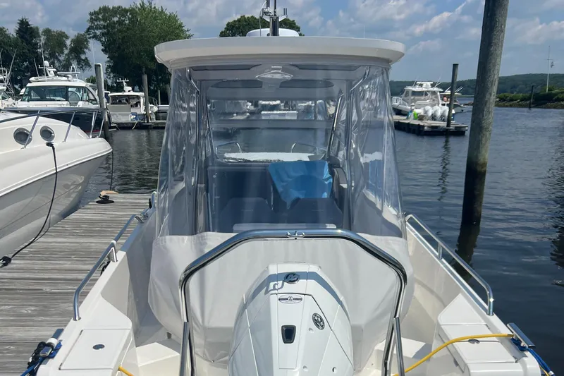 Chill Yacht Photos Pics 2025 Nimbus T8 boat docked at marina, clear canopy, calm water, sunny day.