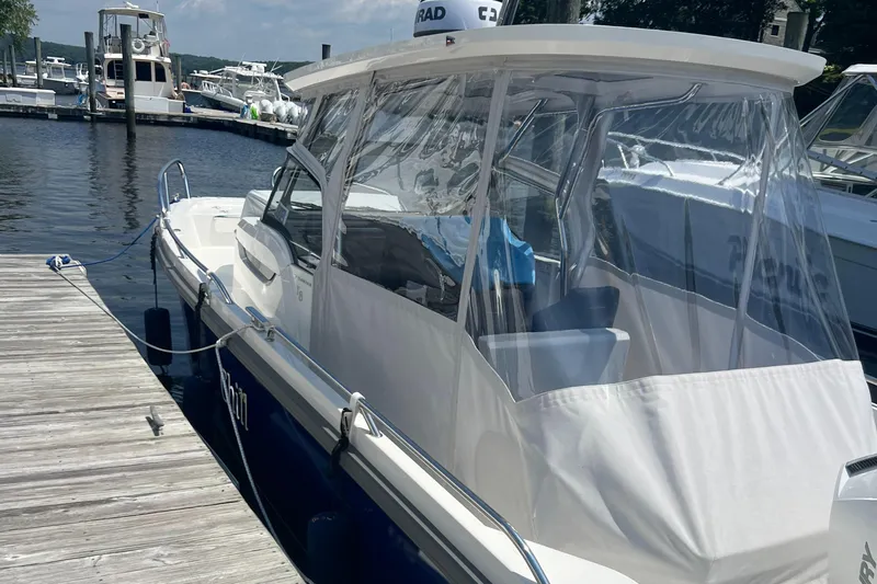 Chill Yacht Photos Pics Nimbus T8 2025 boat docked at marina with clear canopy and blue accents.