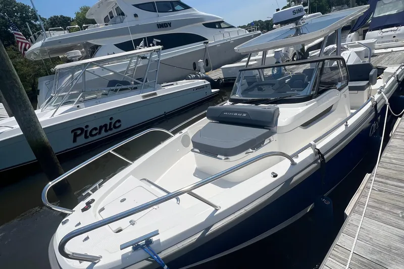 Chill Yacht Photos Pics 2025 Nimbus T8 boat docked at marina, surrounded by other vessels.
