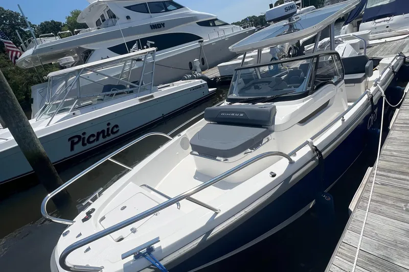 Chill Yacht Photos Pics 2025 Nimbus T8 boat docked alongside other vessels in a marina.