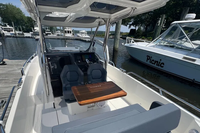 Chill Yacht Photos Pics Modern Nimbus T8 boat interior with seating and table, docked at a marina, 2025 model.