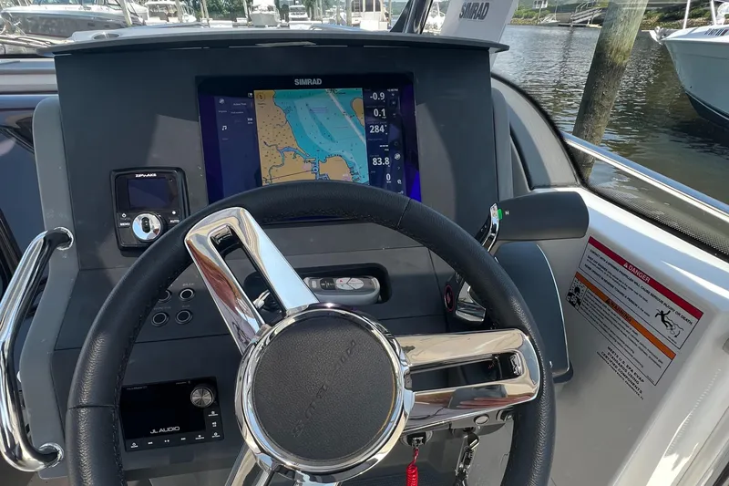 Chill Yacht Photos Pics Steering wheel and navigation system of 2025 Nimbus T8 boat, docked by the water.
