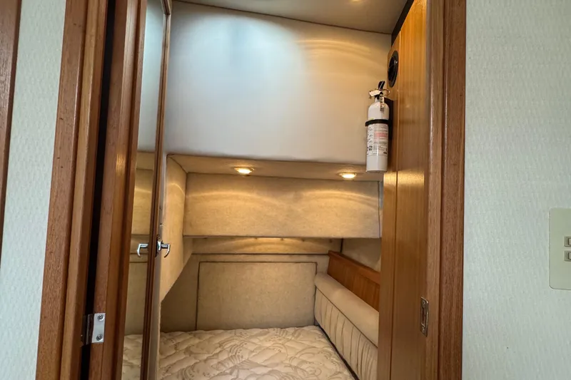 Interim Yacht Photos Pics 2001 Bayliner 4087 Aft Cabin Motoryacht interior with cozy bed and fire extinguisher.