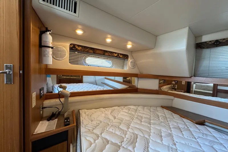 Interim Yacht Photos Pics 2001 Bayliner 4087 Aft Cabin Motoryacht interior with cozy bed and wooden accents.