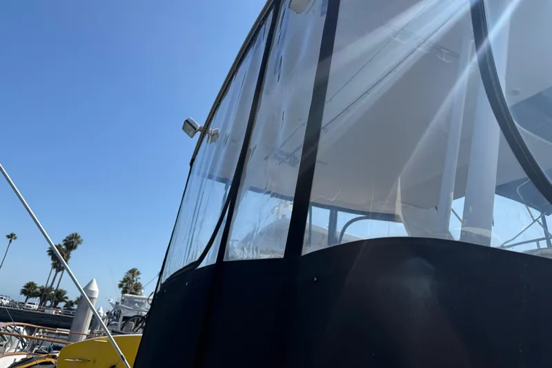 Interim Yacht Photos Pics 2001 Bayliner 4087 Aft Cabin Motoryacht with clear enclosure under sunny sky.