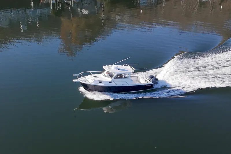 Challenger Yacht Photos Pics 2021 NorthCoast 315 HT boat cruising on calm water, creating a wake.