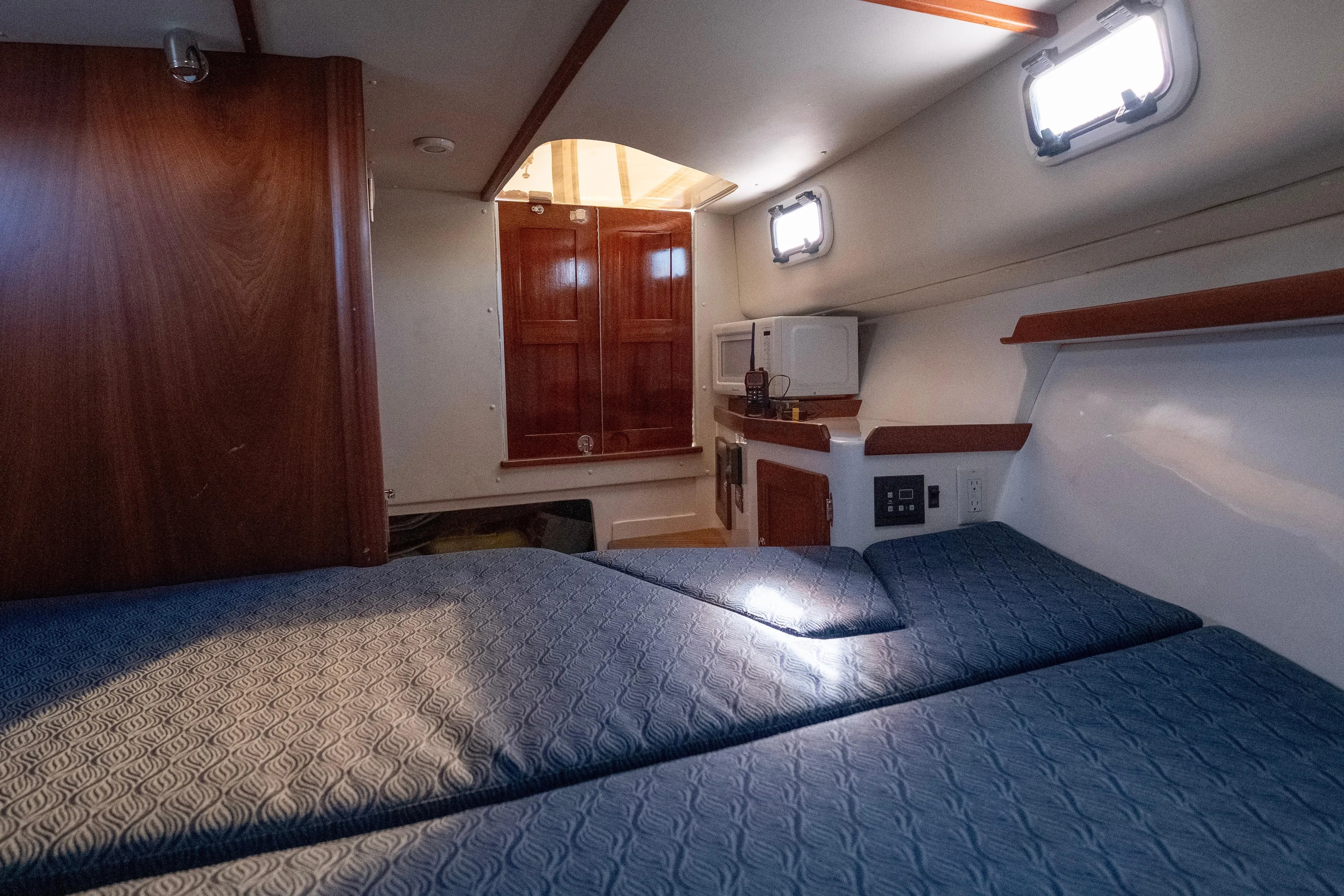 Challenger Yacht Photos Pics 2021 NorthCoast 315 HT cabin interior with blue bedding and wooden accents.