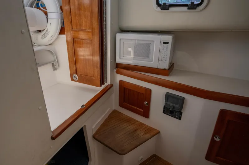 Challenger Yacht Photos Pics 2021 NorthCoast 315 HT cabin interior with microwave and wooden cabinetry.