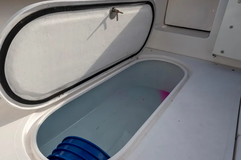 Challenger Yacht Photos Pics Open storage compartment on 2021 NorthCoast 315 HT boat with blue bucket inside.