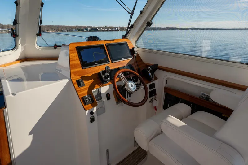 Challenger Yacht Photos Pics Interior view of 2021 NorthCoast 315 HT boat helm with dual screens and wooden accents.