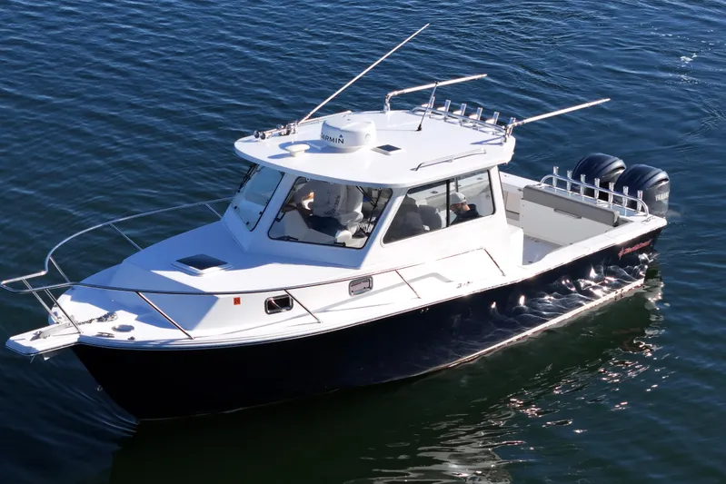 Challenger Yacht Photos Pics 2021 NorthCoast 315 HT boat cruising on water with dual outboard engines.