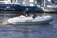 2023 AB Inflatables 350 XP boat navigating in marina waters.