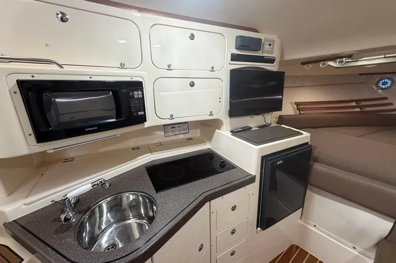  Yacht Photos Pics 2004 Grady-White Express 330 cabin interior with kitchenette, microwave, and TV.